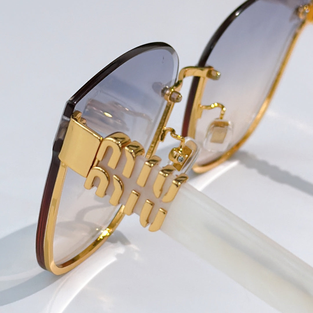 MiuMiu glasses close-up with gold logo hinge and tinted lenses
