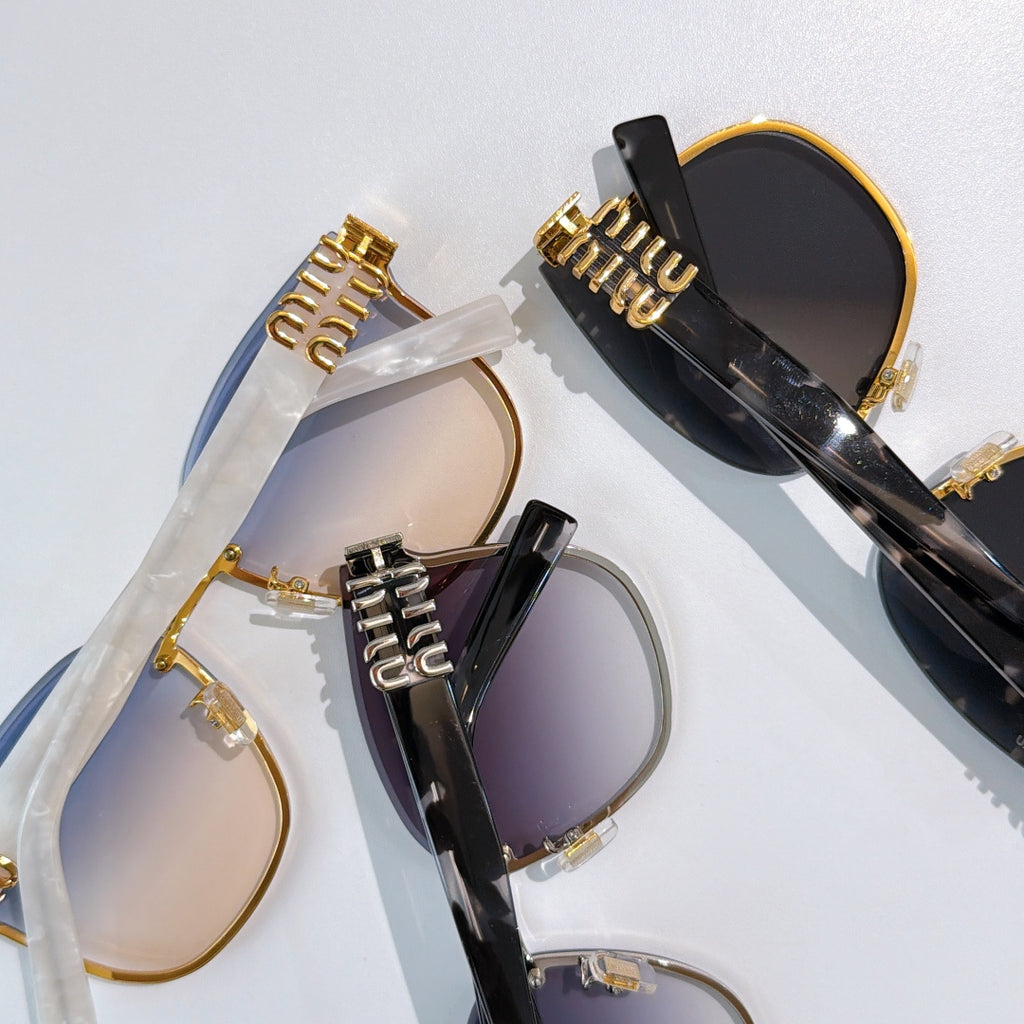 Set of MiuMiu glasses with black and gold frames and tinted lenses