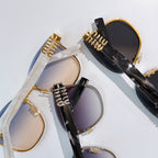 Set of MiuMiu glasses with black and gold frames and tinted lenses