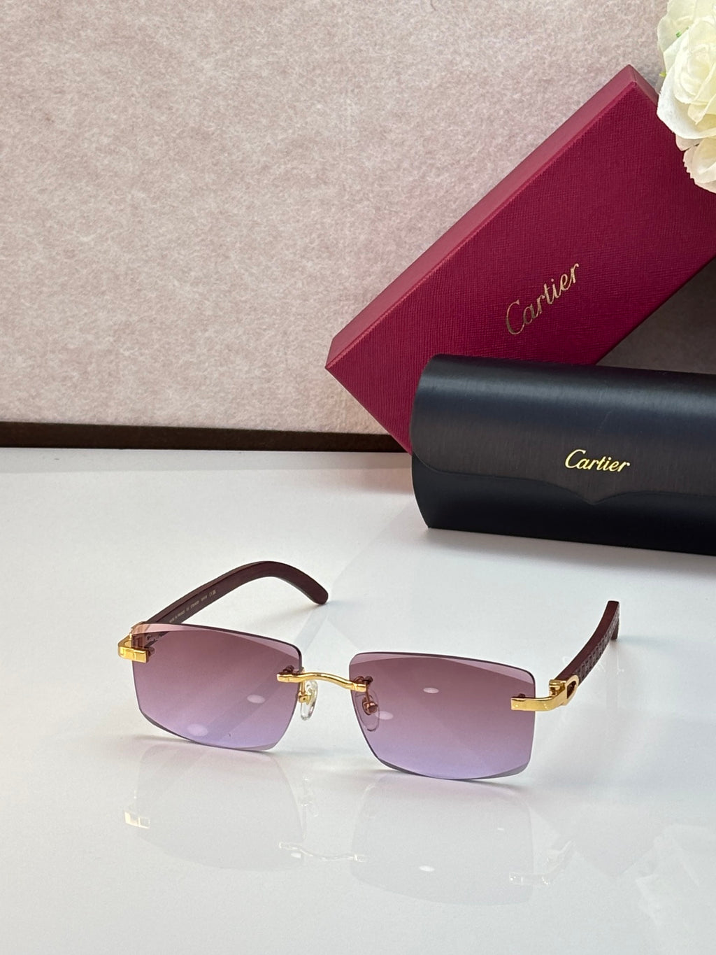 Cartier eyeglasses with dark brown frames and pink-purple gradient lenses, gold accents