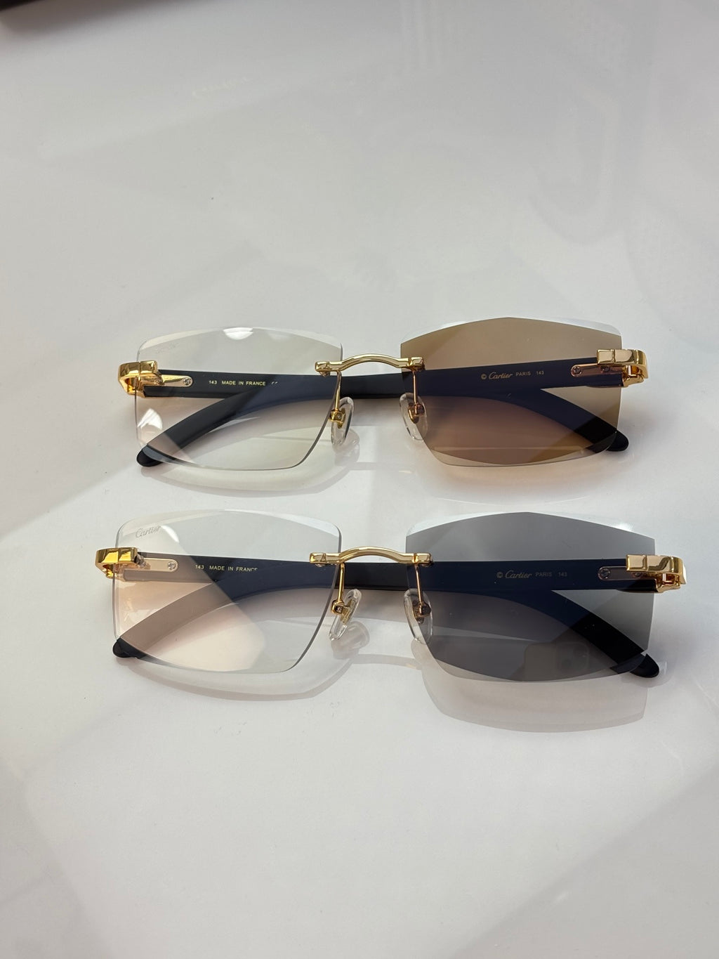 Pair of eyeglasses with dark rims, clear and brown-tinted lenses, gold accents