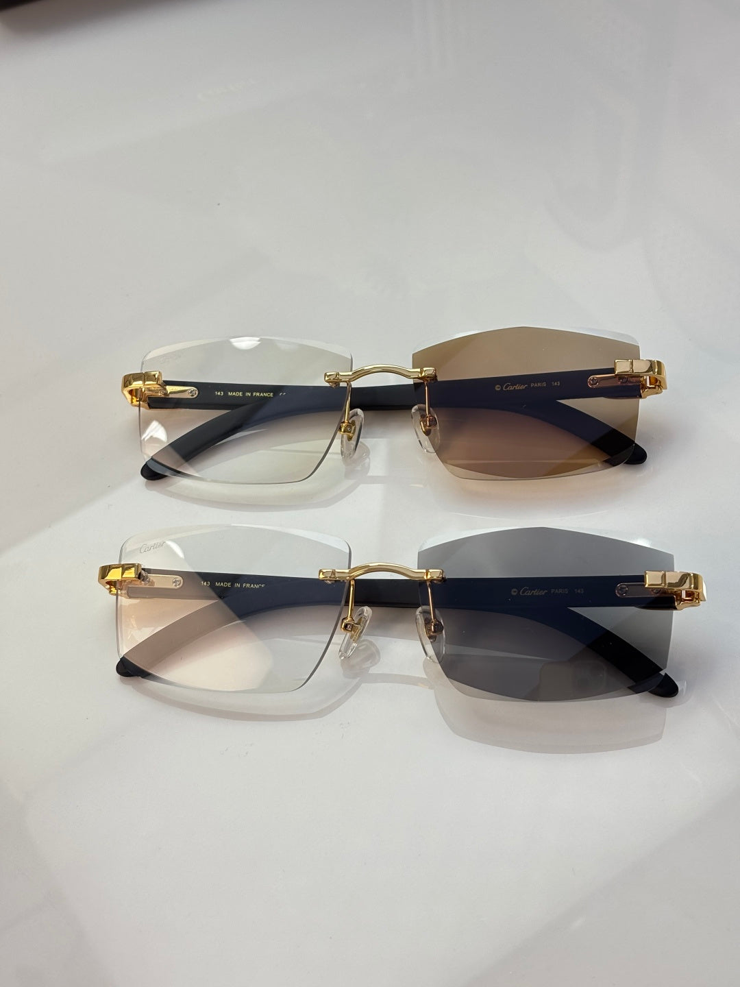 Pair of eyeglasses with dark rims, clear and brown-tinted lenses, gold accents