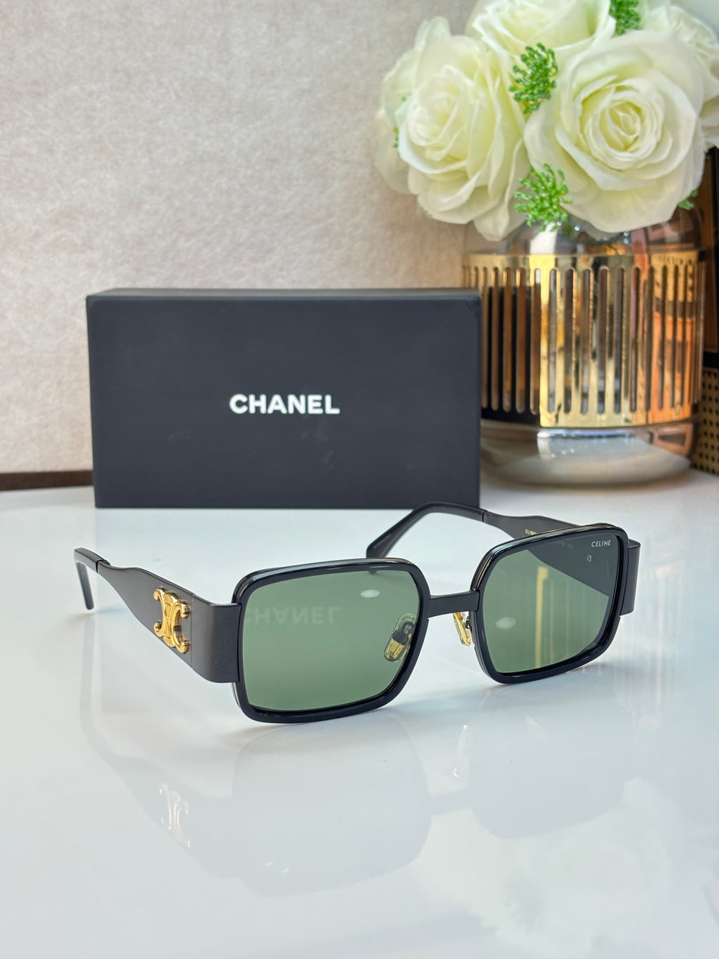Celine glasses with dark frames, green-tinted lenses, and gold logo on temple