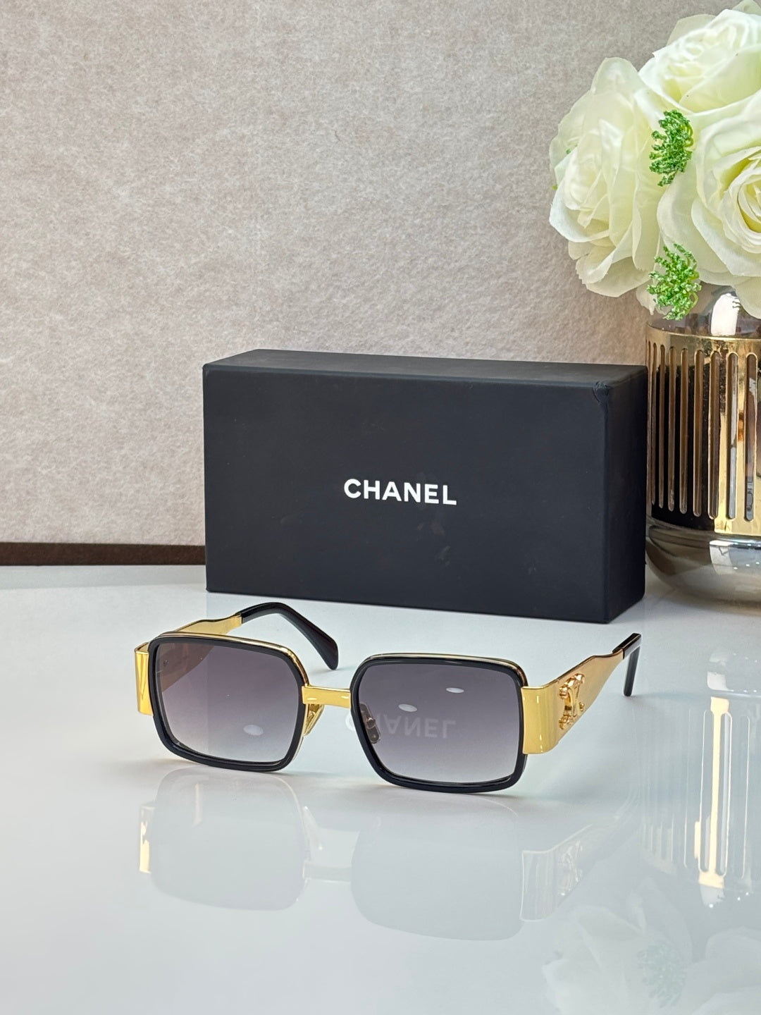 Celine glasses with black frames, brown lenses, and gold side accents