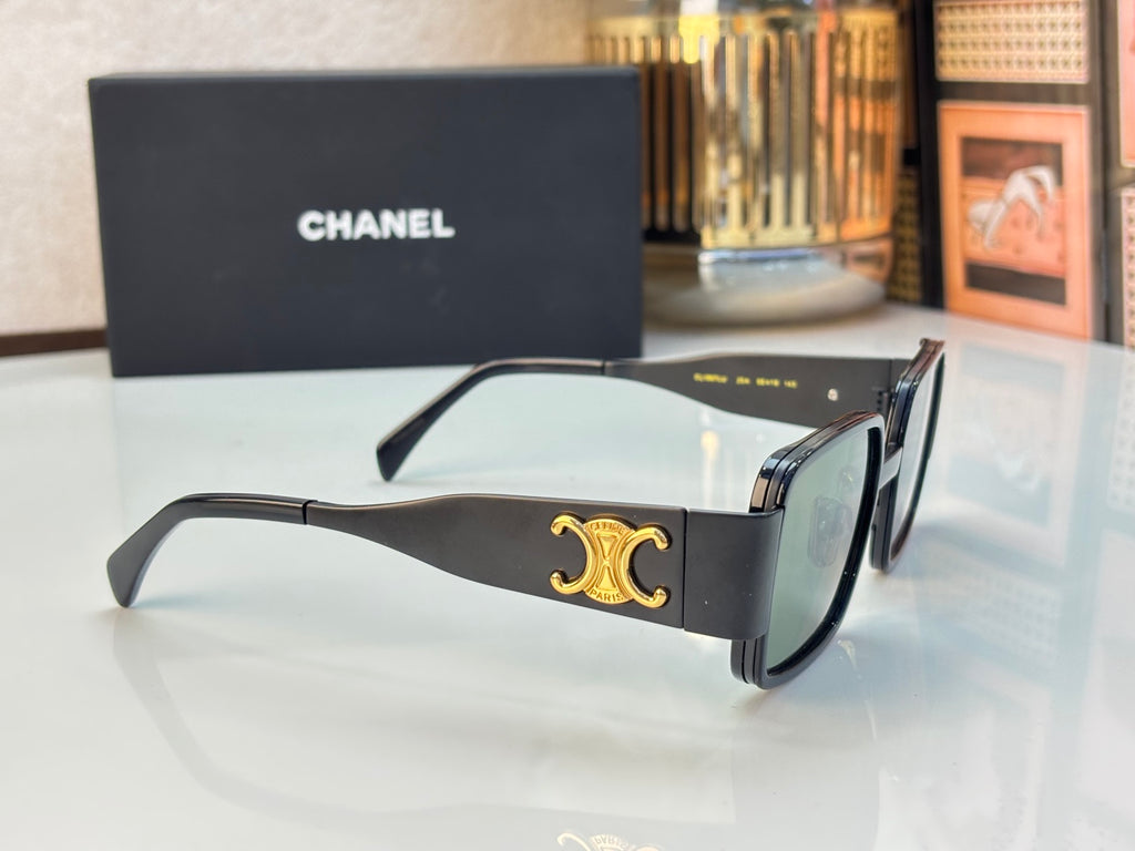 Celine glasses with black frames, green lenses, and gold C logo on temple