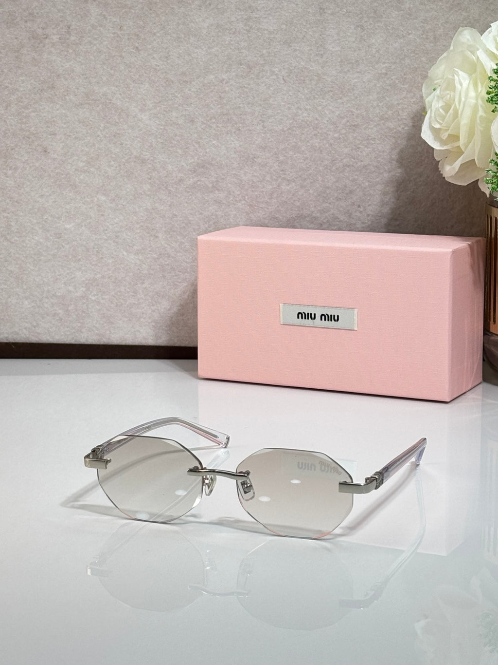 MiuMiu clear-lens round sunglasses with silver arms and thin frames