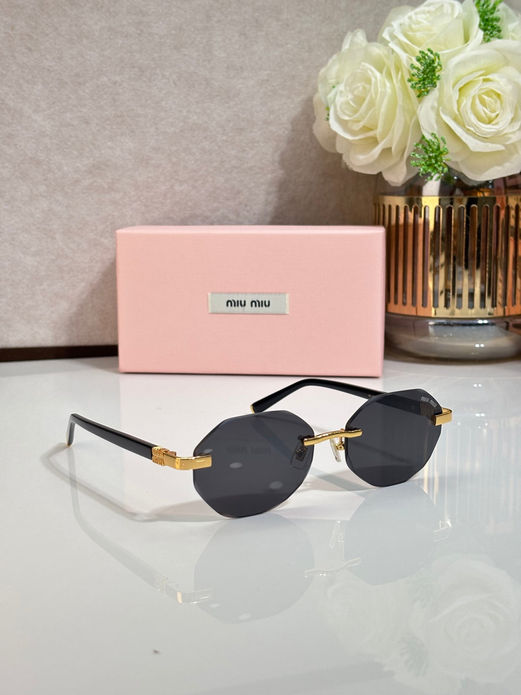 MiuMiu black round sunglasses with gold detailing and clear nose pads