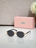 MiuMiu black round sunglasses with gold arms and dark lenses