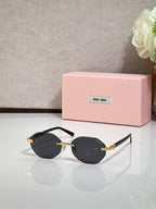 MiuMiu black round sunglasses with gold arms and dark lenses