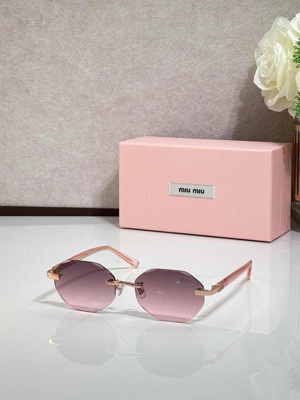 MiuMiu rose-tinted round sunglasses with gold arms and light frames