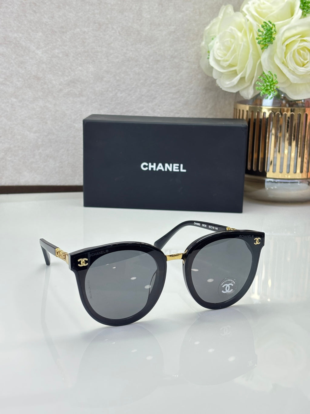 Chanel sunglasses with black cat-eye frames and dark gray lenses