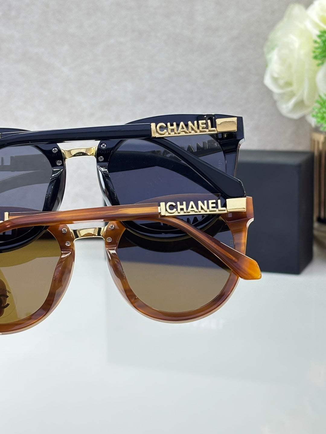 Chanel sunglasses duo with black and tortoiseshell frames and tinted lenses