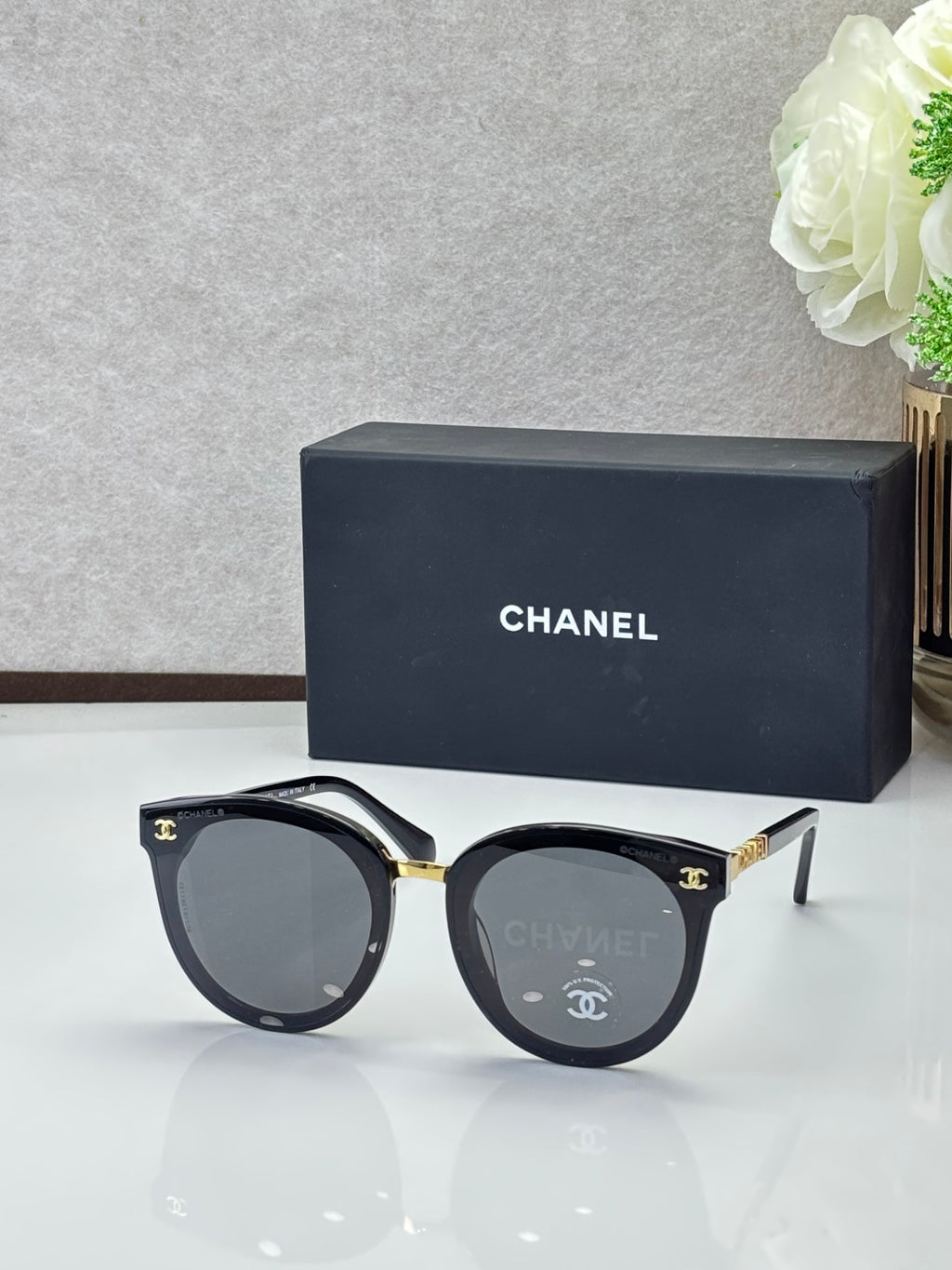 Chanel sunglasses with black round frames and gray tinted lenses
