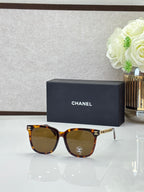 Chanel sunglasses with warm tortoiseshell frames, dark lenses, and gold logo details on the temples