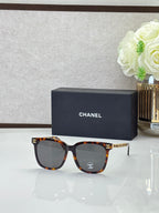 Chanel sunglasses with tortoiseshell frames, dark lenses, and gold logo details on the temples