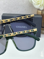 Chanel sunglasses close-up: two frames with gold chain temples, dark blue and green lenses