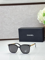 Chanel eyeglasses with black square frames and dark lenses, metal logo temples
