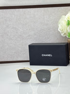 Chanel eyeglasses with cream square frames and dark lenses, gold-tone logo temples