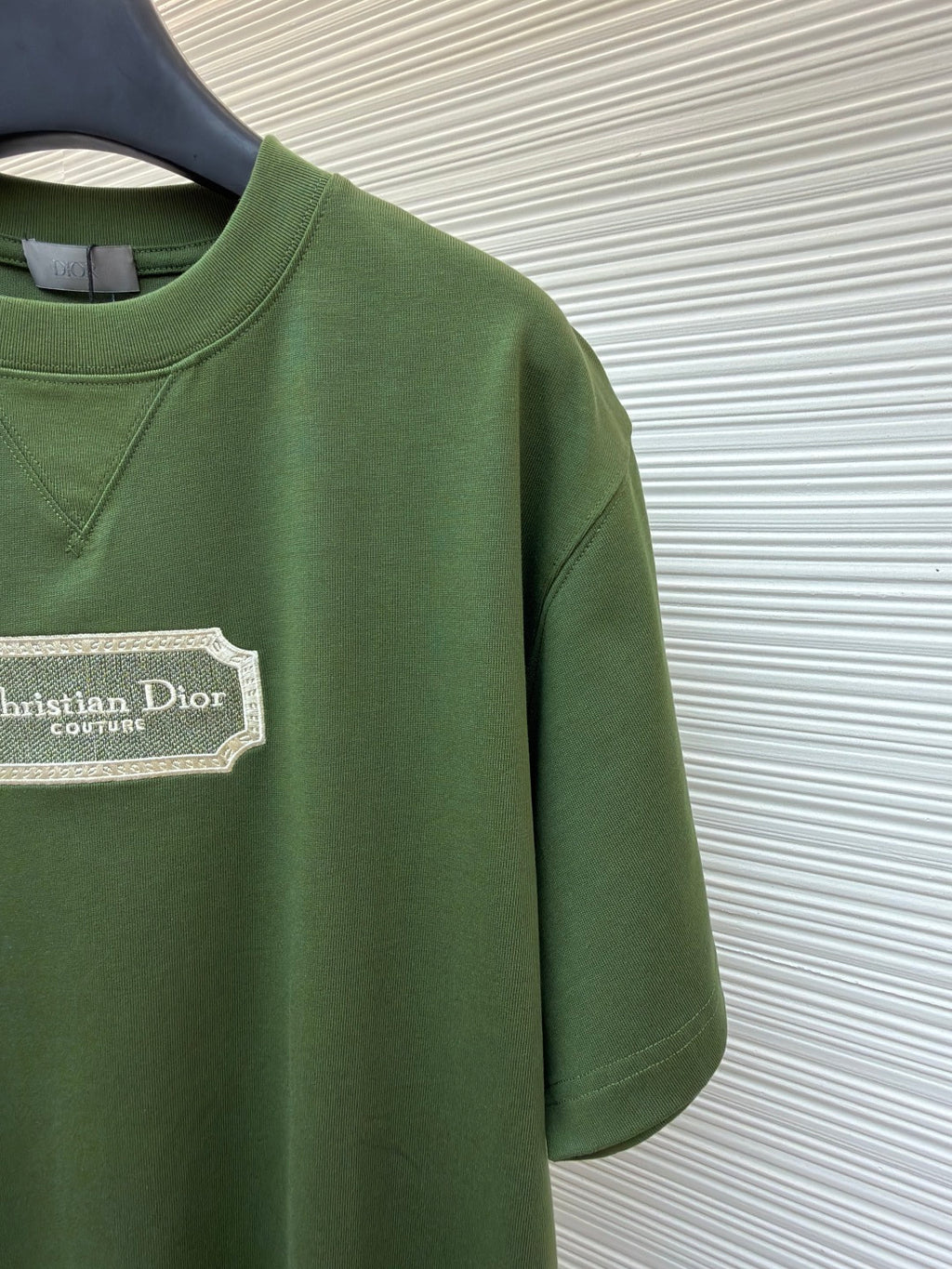 Green T-shirt side view with Christian Dior Couture logo patch