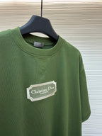 Green T-shirt chest logo and crew neck on hanger