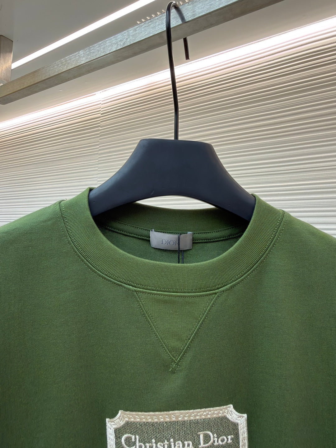 Green T-shirt close-up with Christian Dior Couture chest label