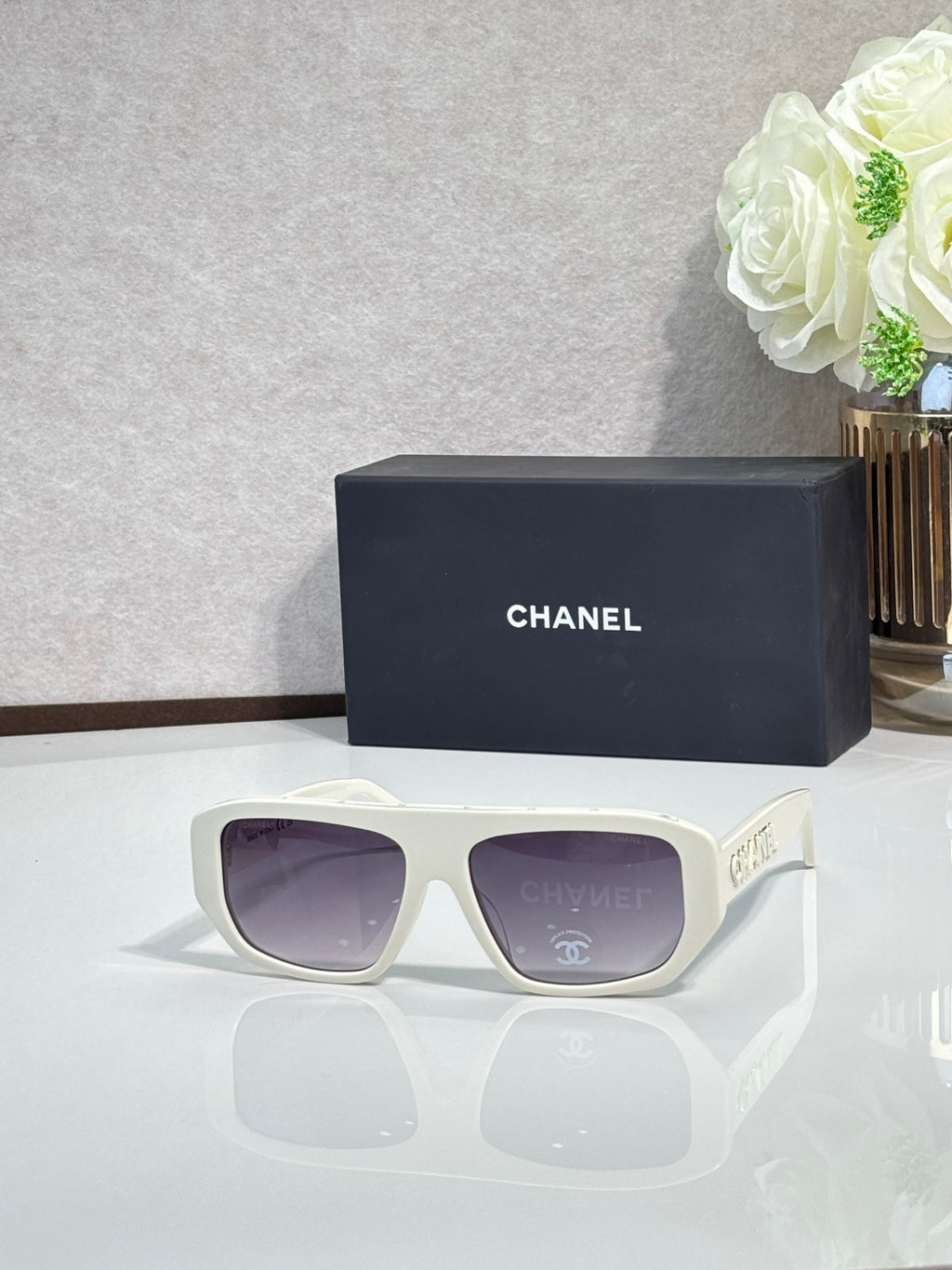 Chanel glasses with white frames and purple tinted lenses, front view