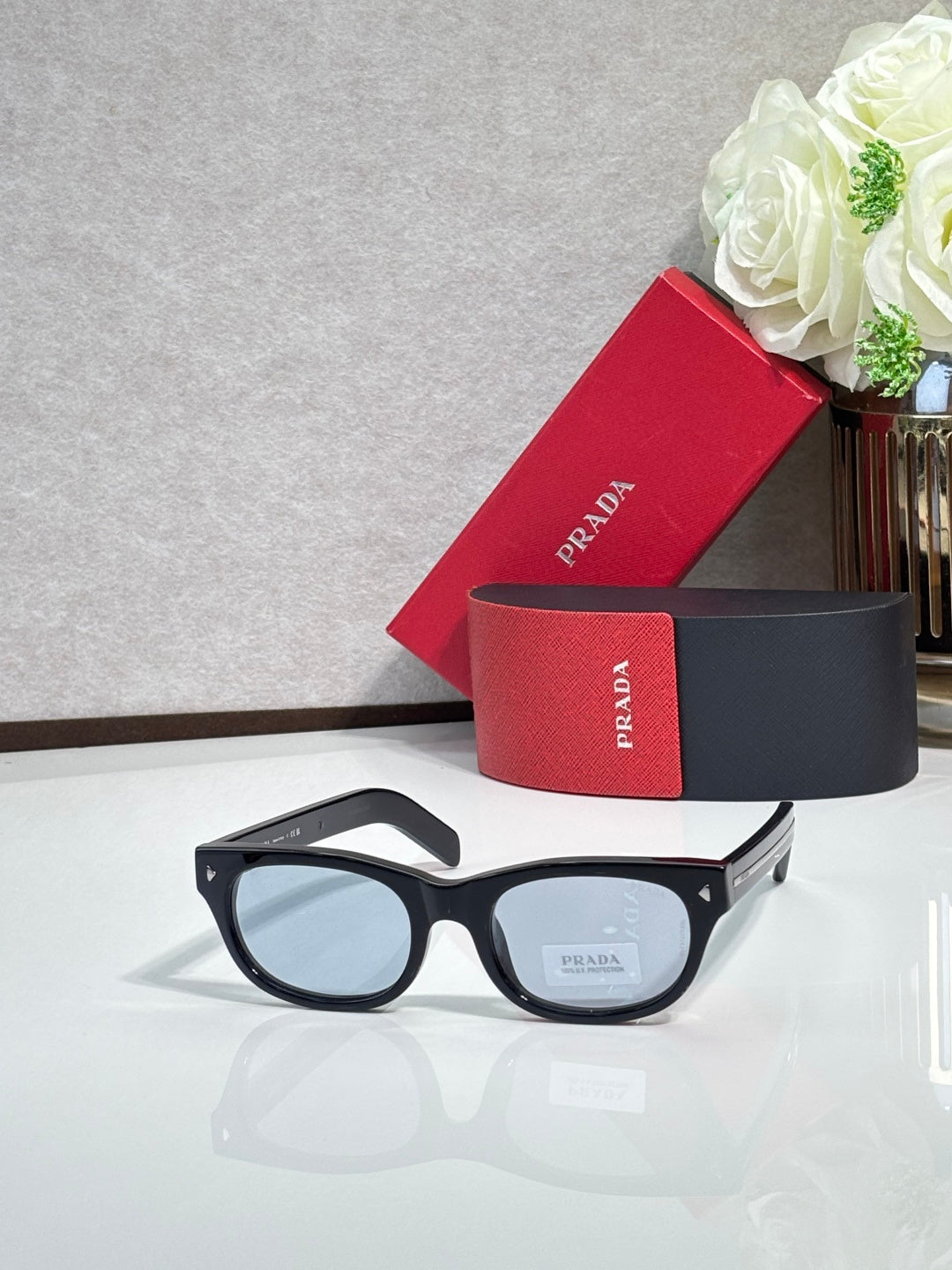 Prada sunglasses with black frame and dark tinted lenses, straight on