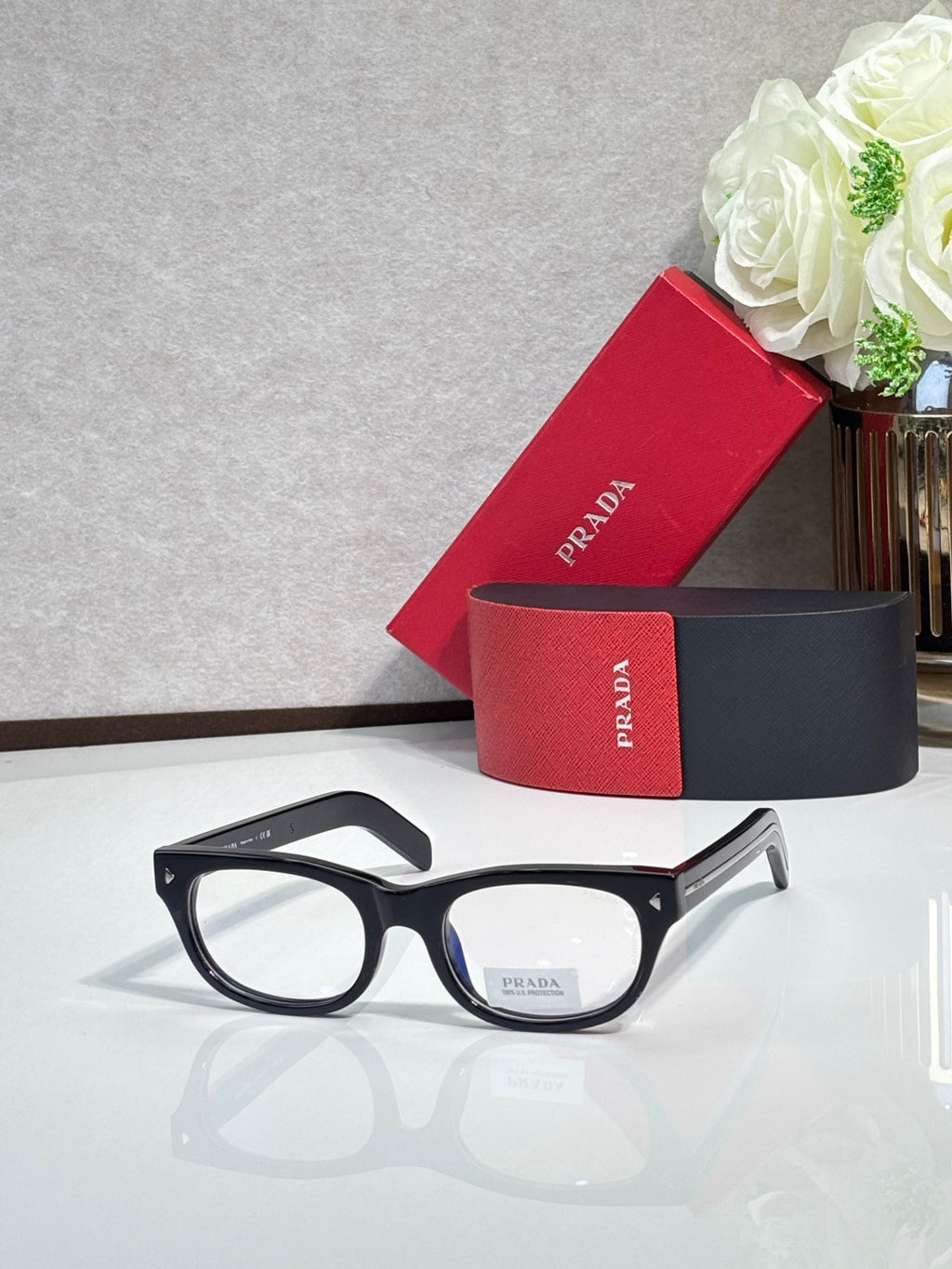 Prada sunglasses with black frame and dark tinted lenses, clean front angle