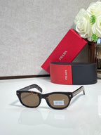 Prada sunglasses with dark frame and brown-tinted lenses, rounded rectangle