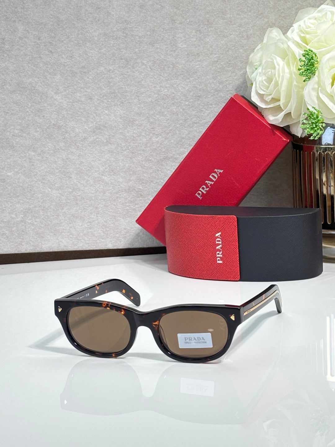 Prada sunglasses with dark frame and brown-tinted lenses, rounded rectangle