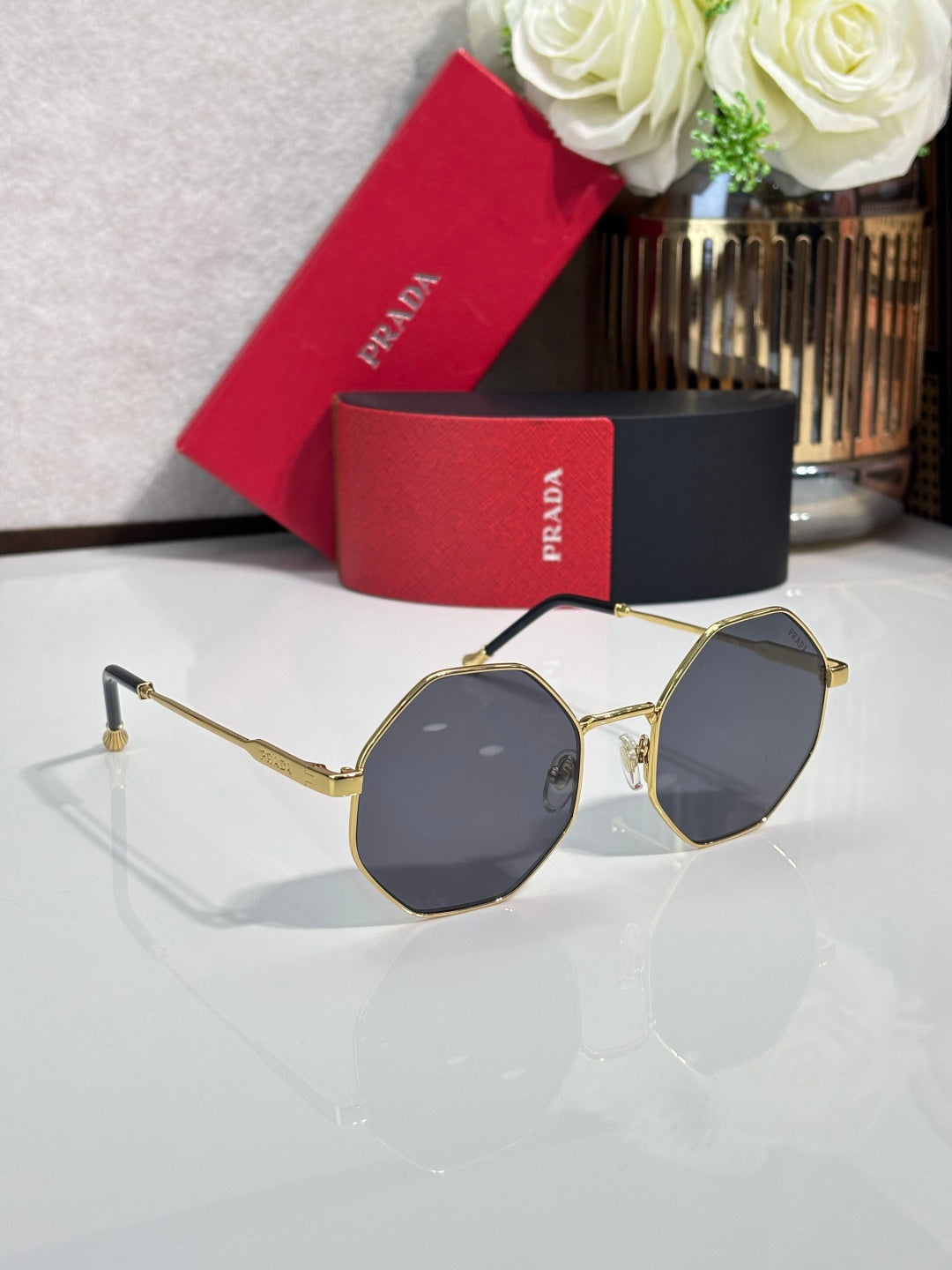 Prada round sunglasses with gold-tone frame and dark lenses