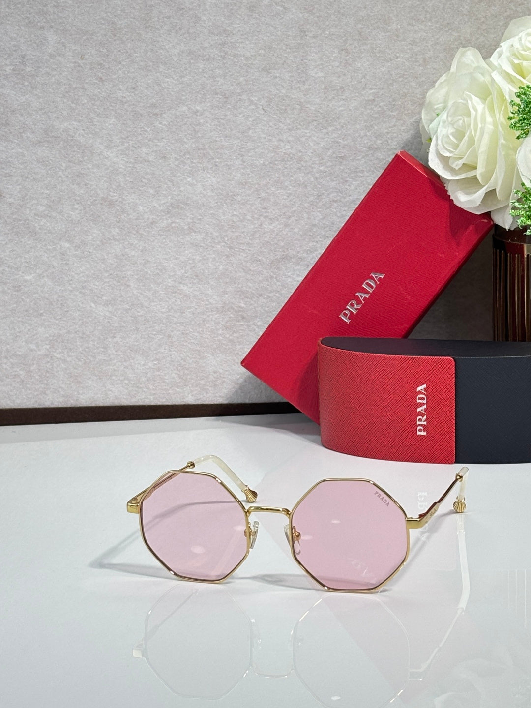 Prada round sunglasses with gold-tone frame and pink-tinted lenses