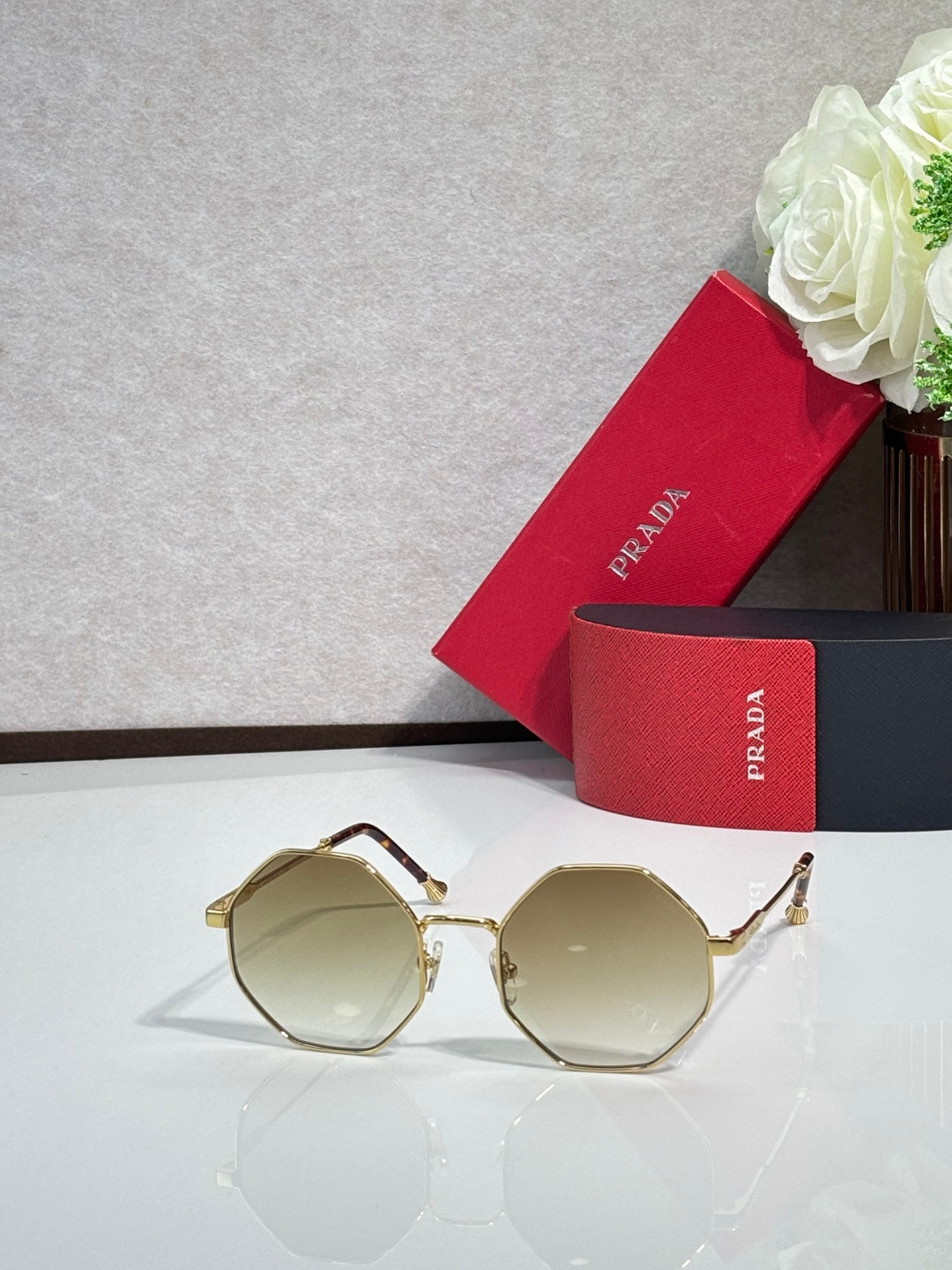 Prada round sunglasses with gold-tone frame and light tinted lenses
