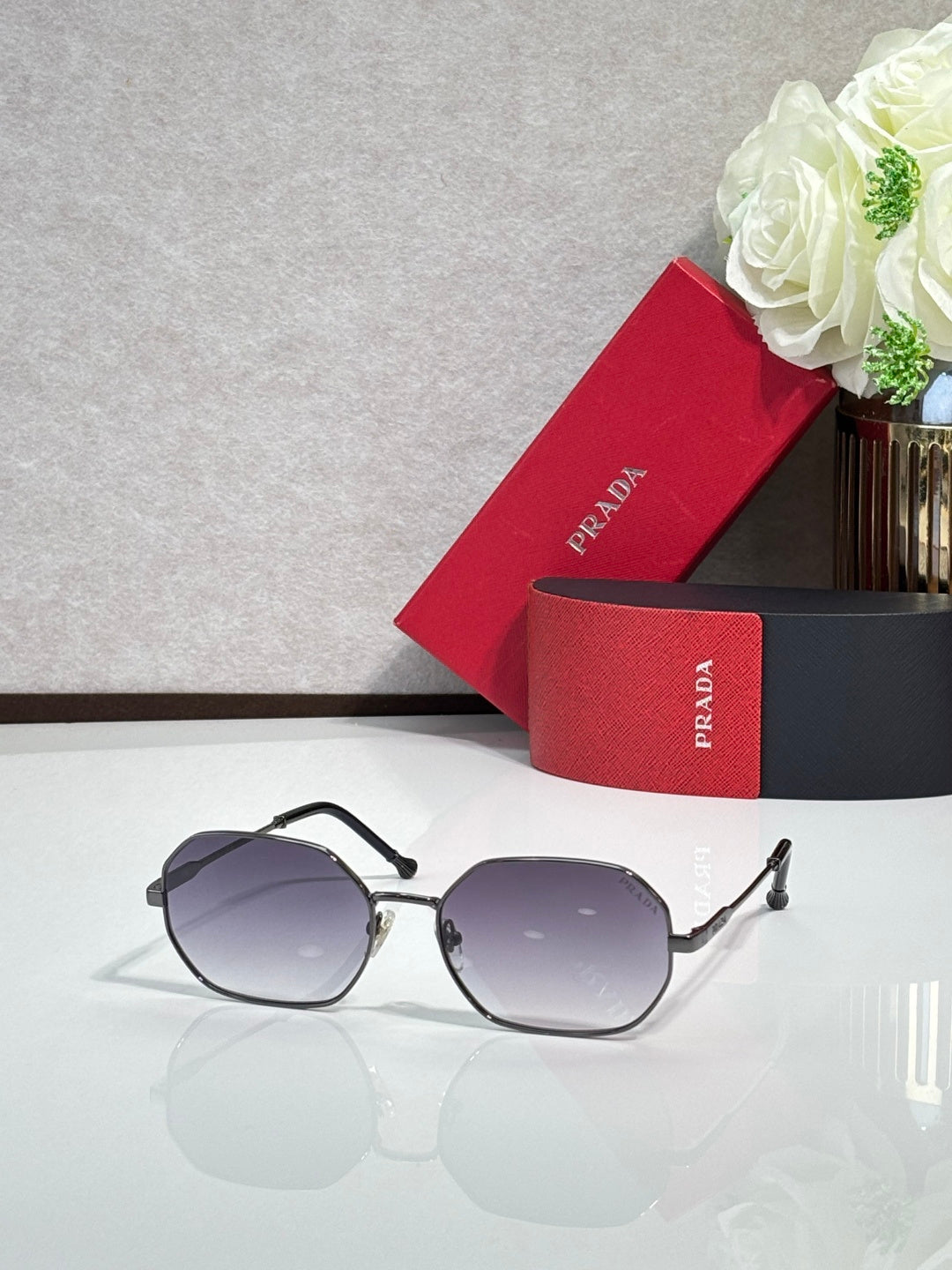 Prada sunglasses with black frame and light gray tinted lenses, oval shape