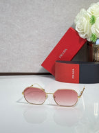 Prada sunglasses with gold-tone frame and pink tinted lenses, rounded oval shape