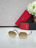 Prada sunglasses with gold-tone frame and beige tinted lenses, oval shape