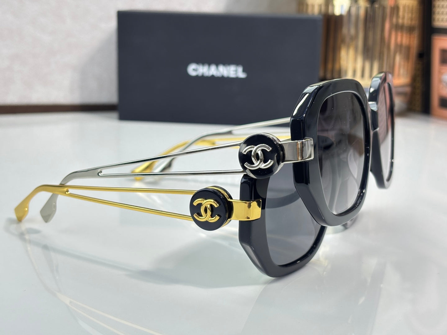 Chanel round cat-eye sunglasses with dark frames, gold arms, and interlocking logo caps