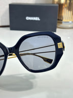 Chanel cat-eye sunglasses close-up with navy frames and gold-tone logo hinge