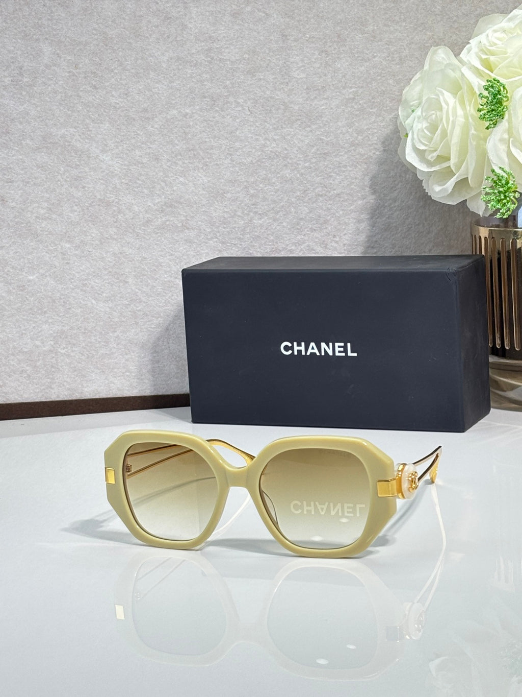 Chanel round cat-eye sunglasses with light yellow frames and gold-tone accents
