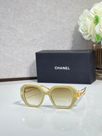 Chanel round cat-eye sunglasses with light yellow frames and gold-tone accents