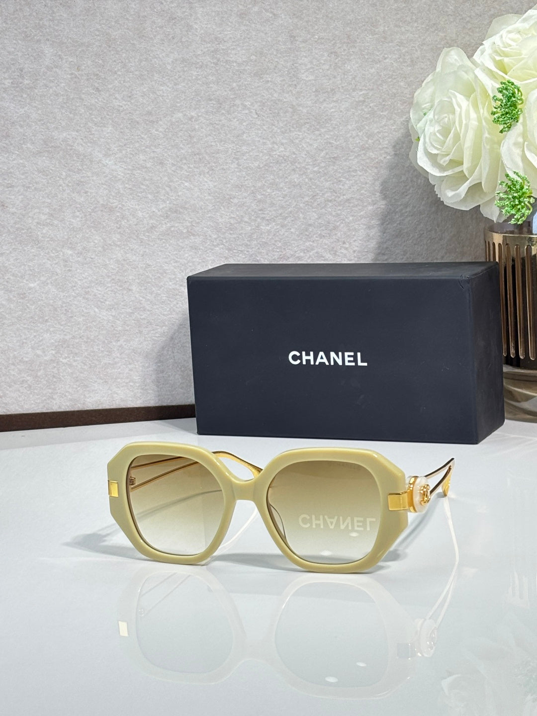 Chanel round cat-eye sunglasses with light yellow frames and gold-tone accents