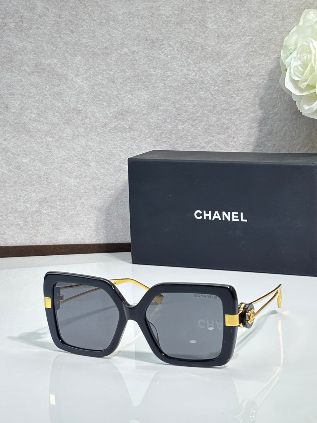 Chanel square sunglasses with black frames and gold-tone hinges