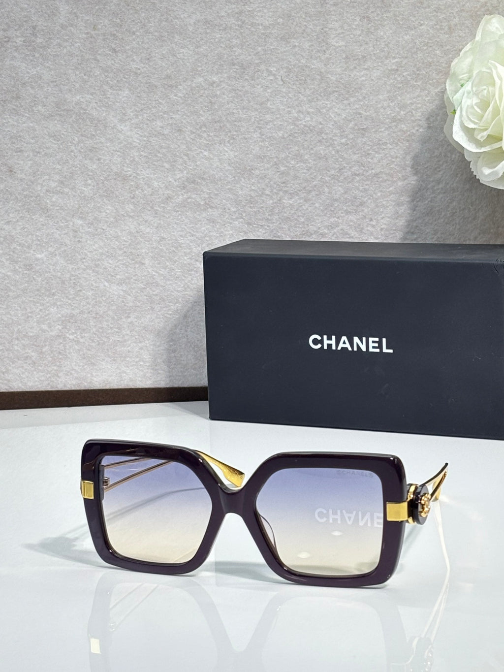 Chanel square sunglasses with deep plum frames and gold-tone hinges
