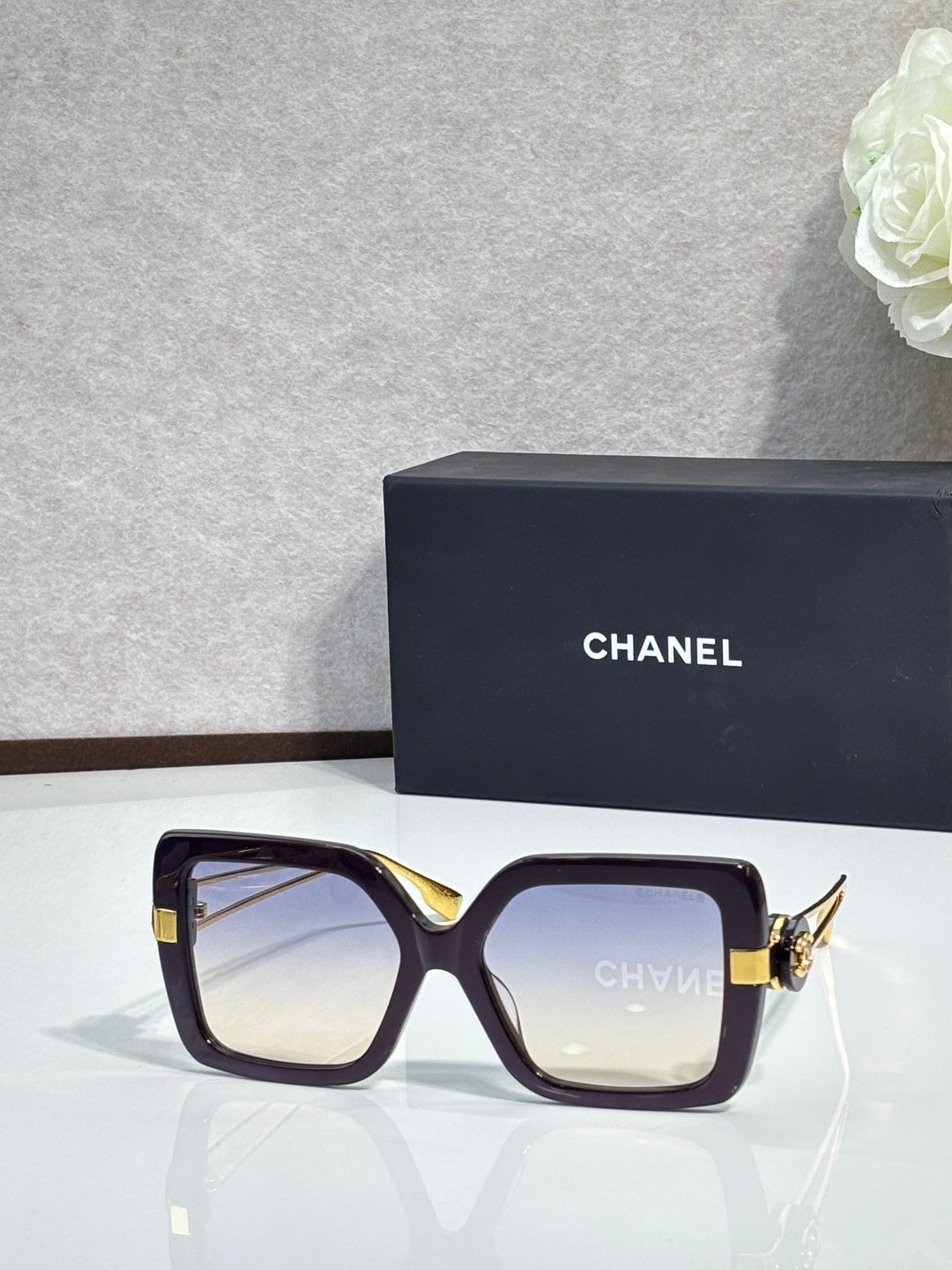 Chanel square sunglasses with deep plum frames and gold-tone hinges