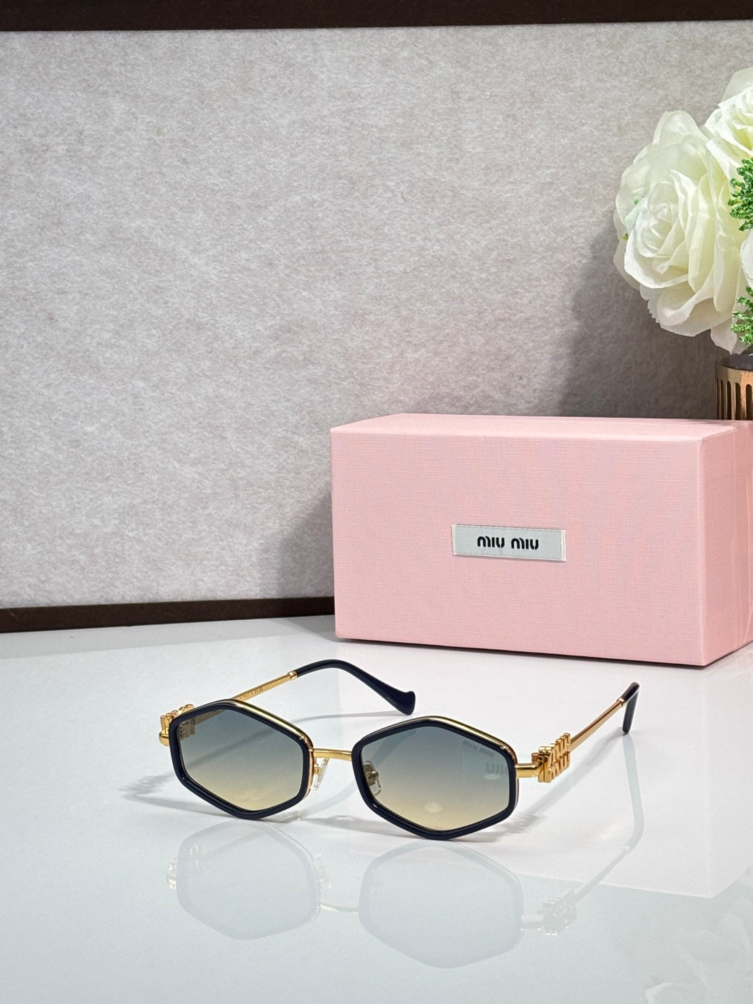 MiuMiu black octagonal sunglasses with blue-tinted lenses and metal arms