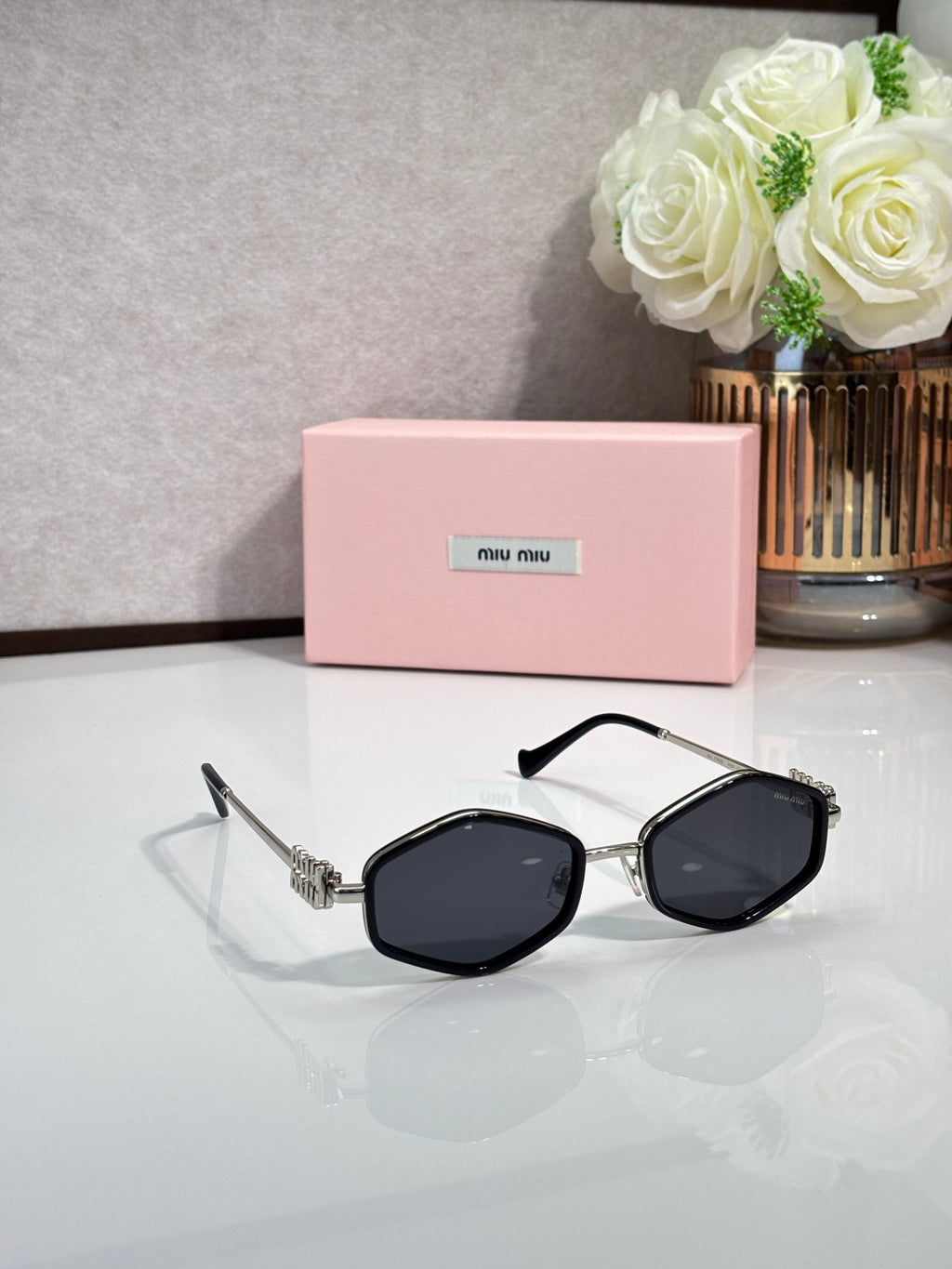 MiuMiu black octagonal sunglasses with dark lenses and metal arms
