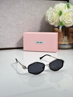 MiuMiu black octagonal sunglasses with dark lenses and metal arms