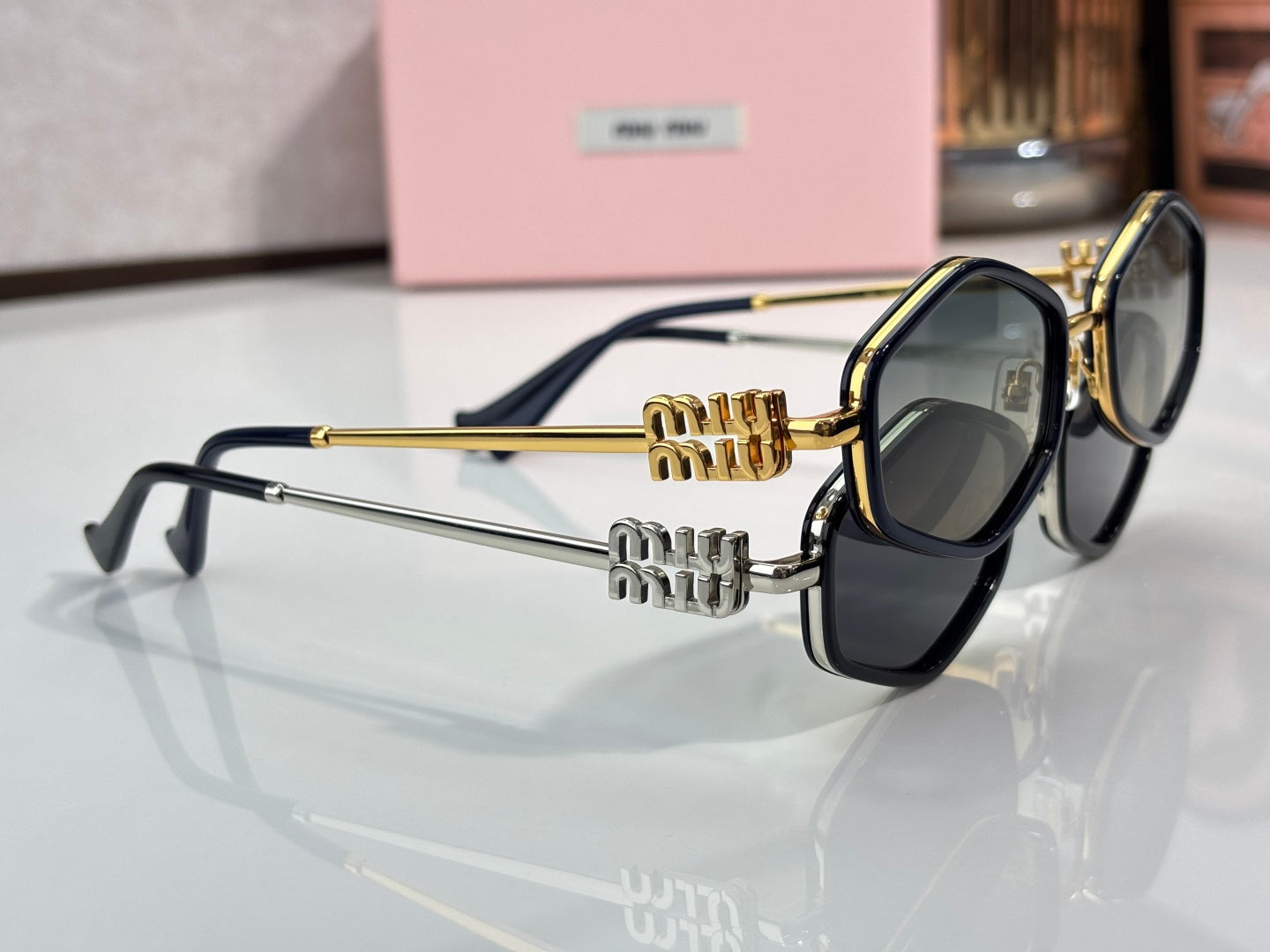 MiuMiu gold and black sunglasses with dark lenses and engraved temple detailing