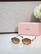 MiuMiu dark octagonal sunglasses with amber-tinted lenses and metal arms