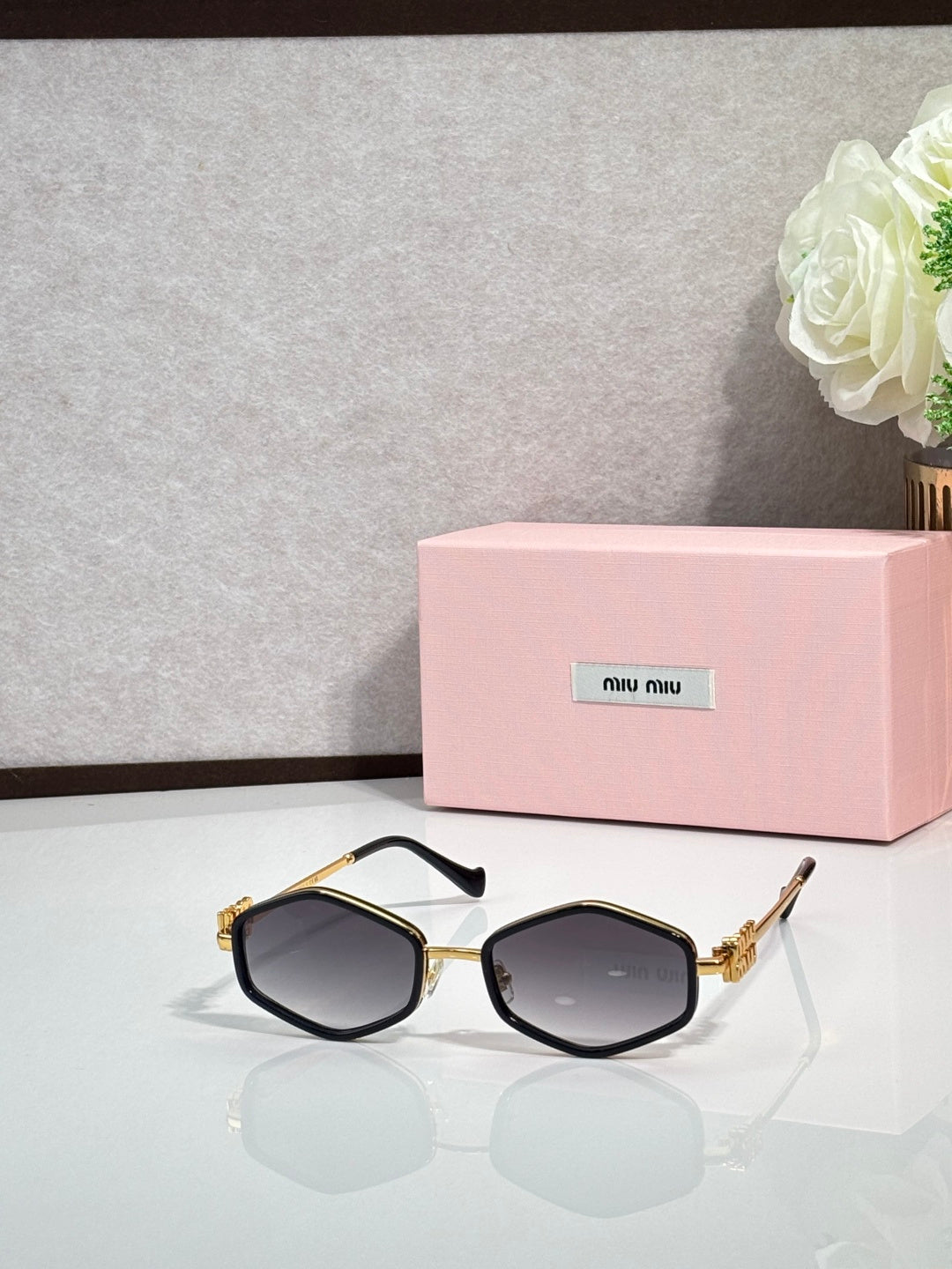 MiuMiu gold octagonal sunglasses with dark lenses and metal arms